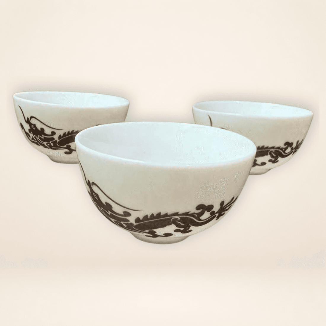 Three white miniature Chinese tea cups with matching black dragon decoration