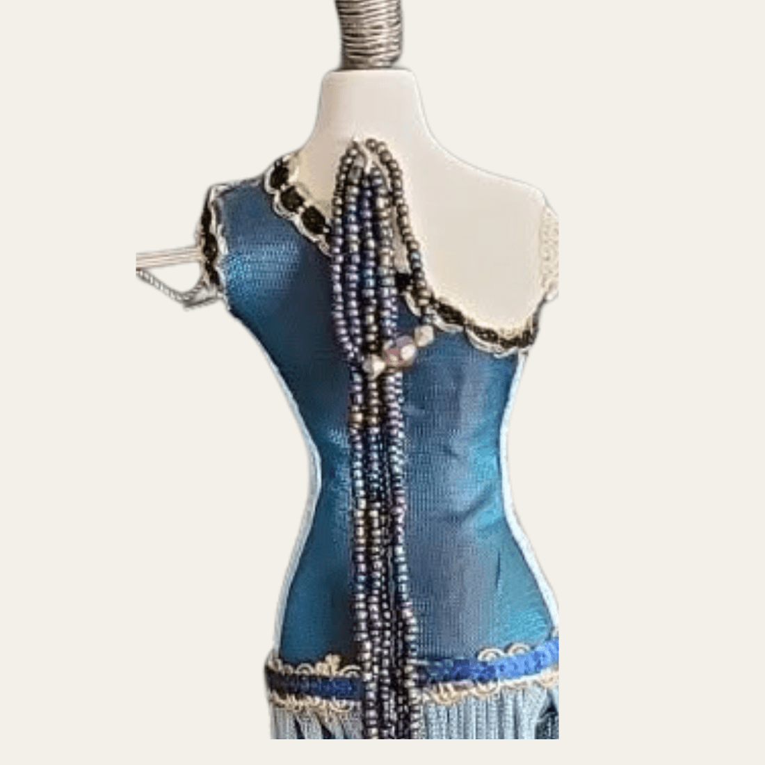 Rear detail of blue mannequin jewellery stand with hanging bead strands