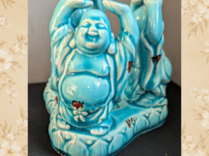Vintage turquoise Laughing Buddha candle holder front three-quarter view