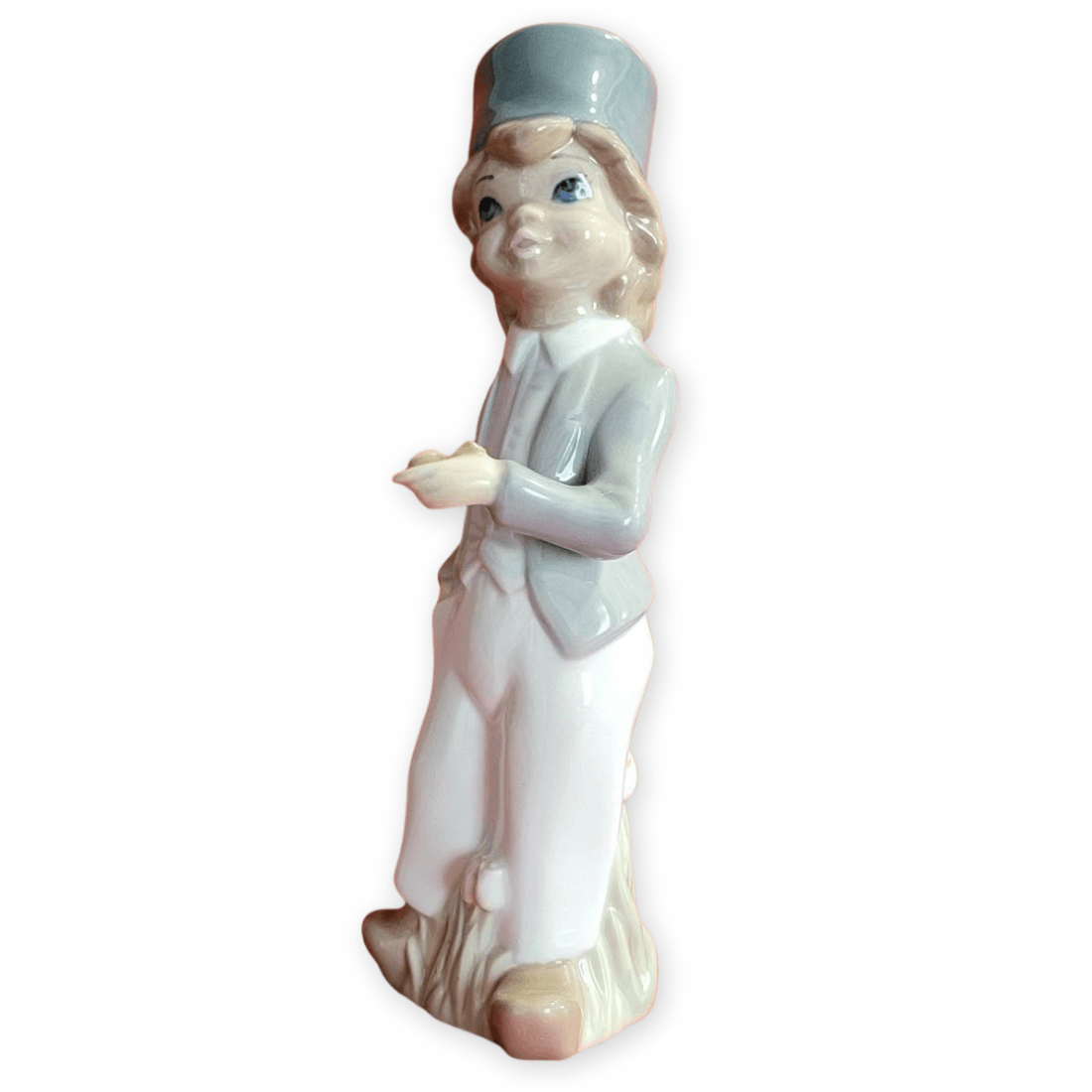 Three-quarter view of the porcelain boy showing his jacket, pipe-holding hand and brown shoes
