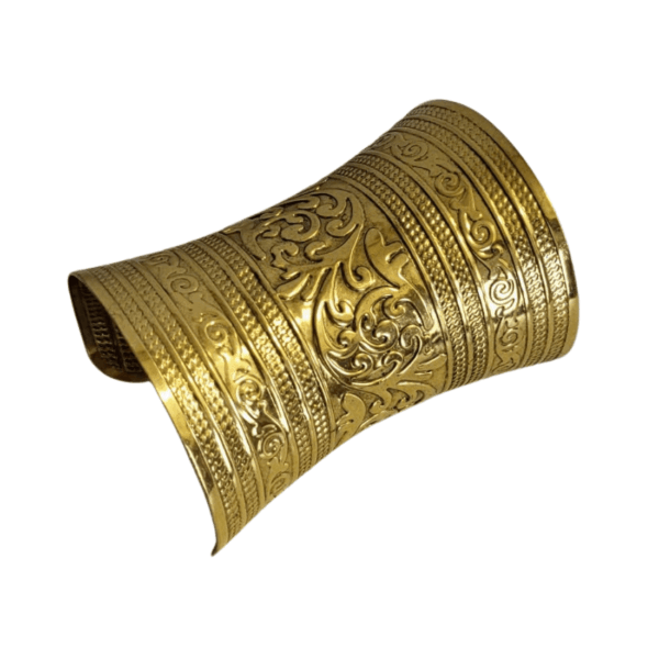Angled view of a wide gold-tone arm cuff bracelet with embossed scroll decoration