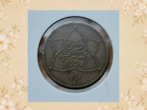 Vintage Moroccan metal token, front view, showing a circular geometric design.