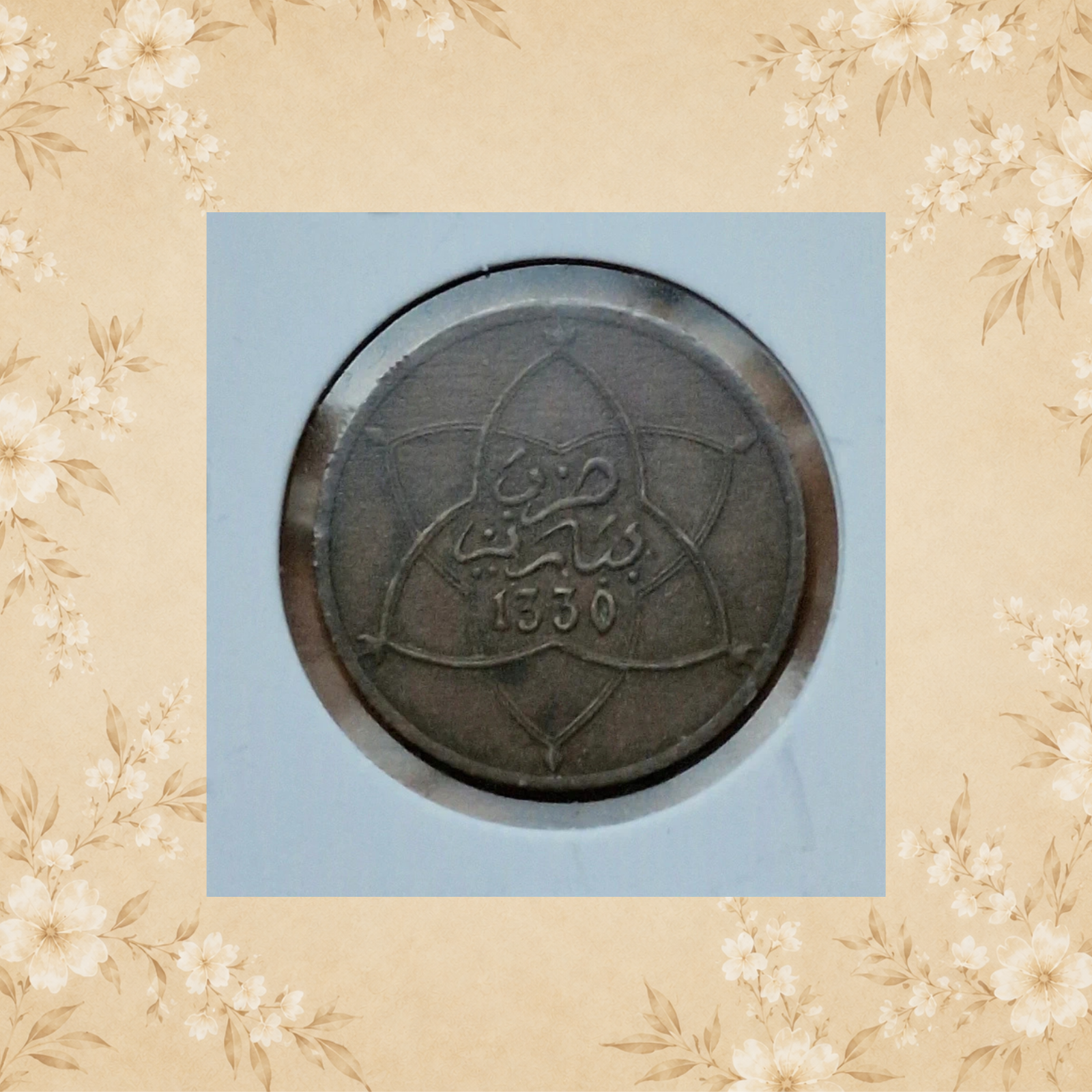Vintage Moroccan metal token, front view, showing a circular geometric design.