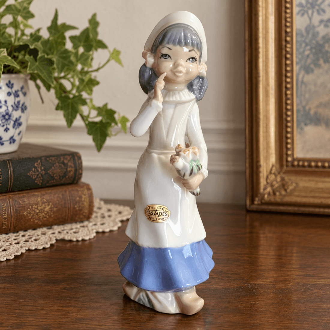 Casades porcelain girl figurine with flowers displayed on a wooden table