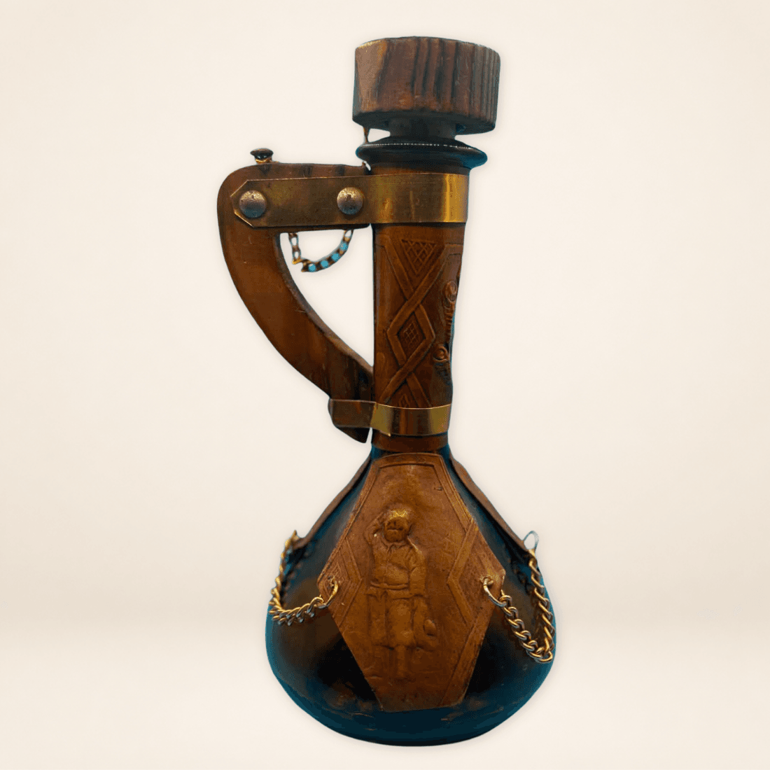 Rear view of leather-wrapped vintage decanter showing embossed figure panel and wooden handle