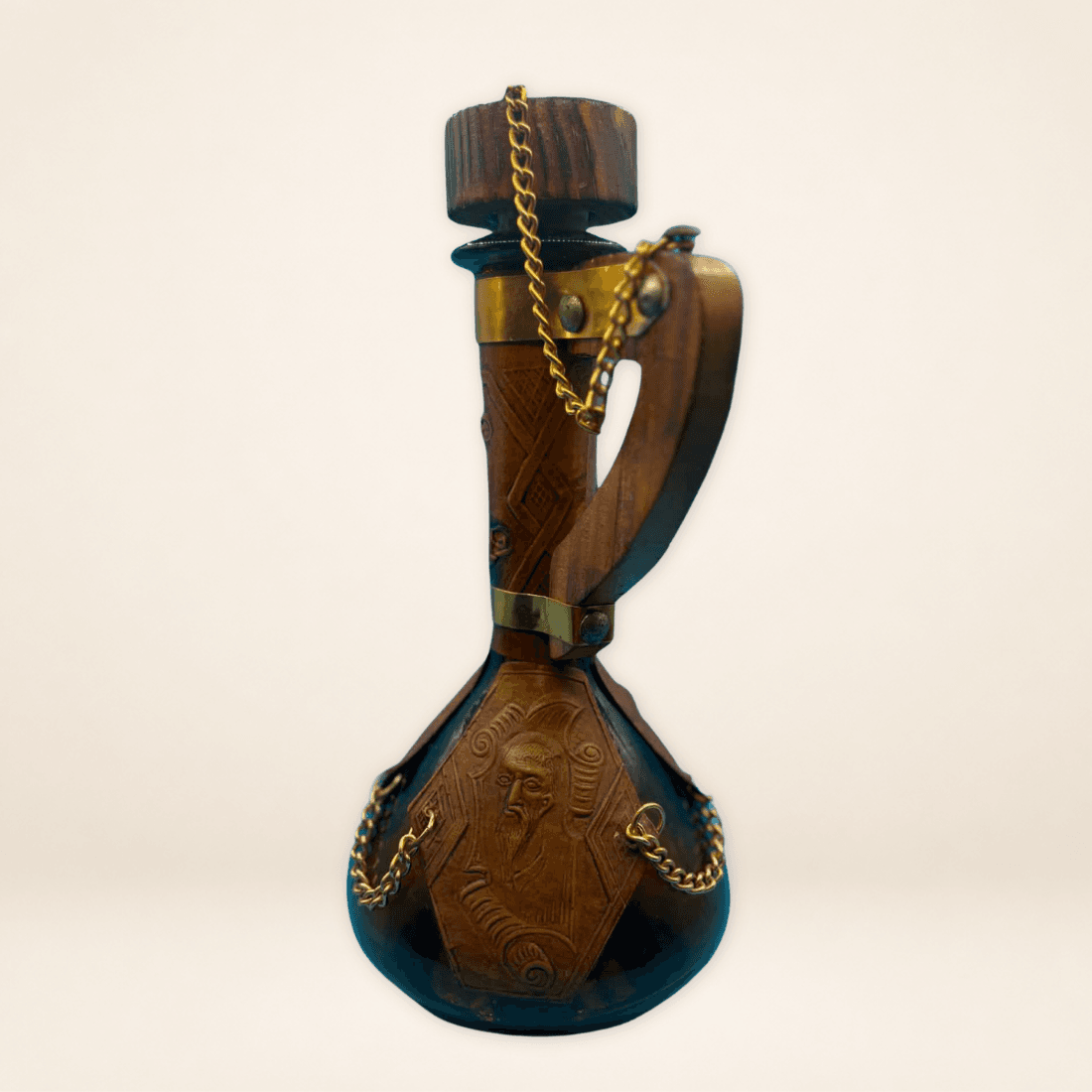 Side view of vintage leather decanter showing carved leather detail, wooden handle and decorative chain