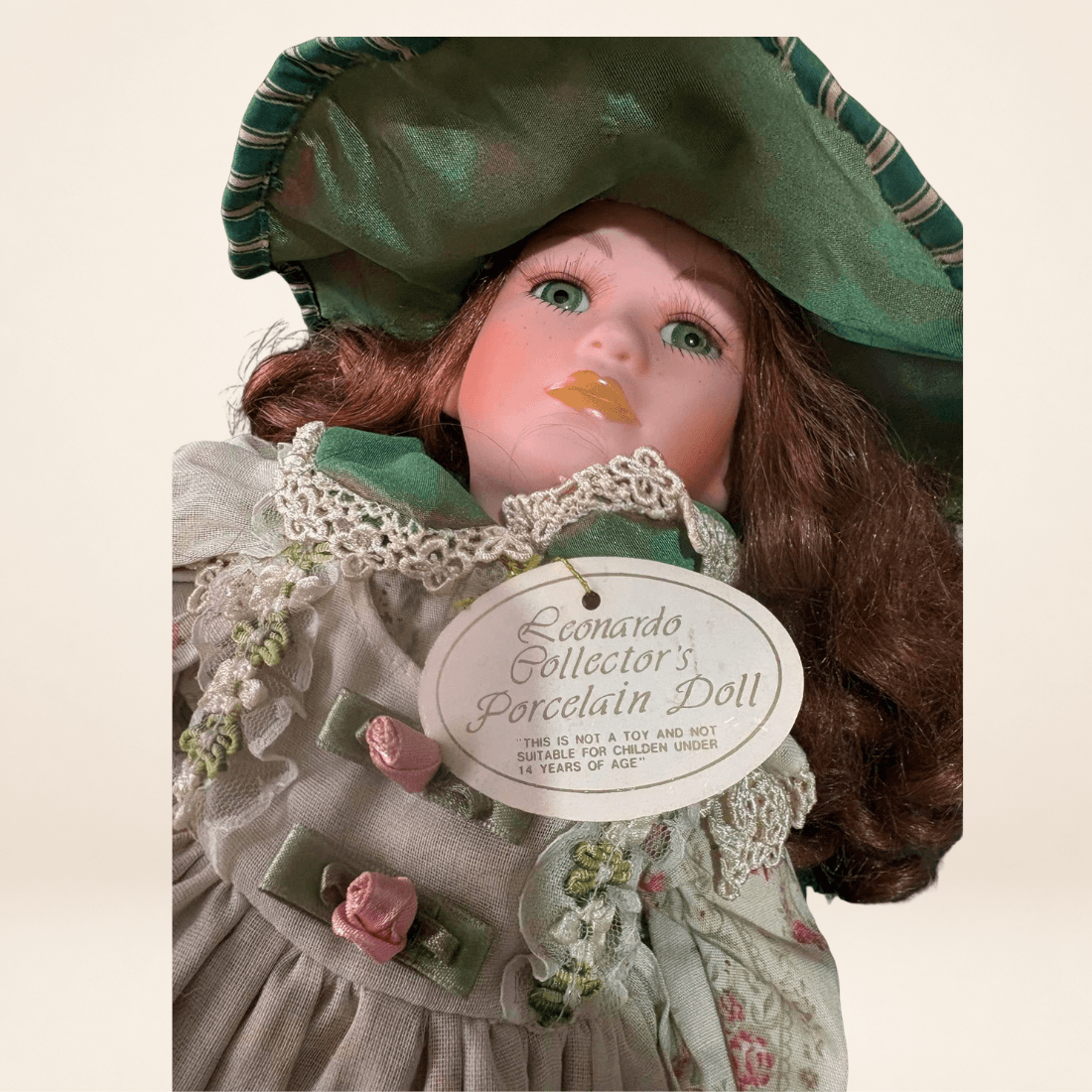 Close-up of Leonardo Collection Rowena doll with original porcelain doll tag