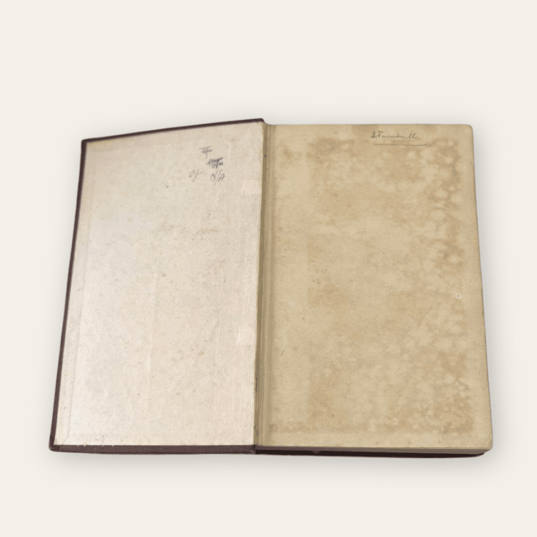 Front endpaper and inside cover with handwritten ownership markings and pronounced brown spotting