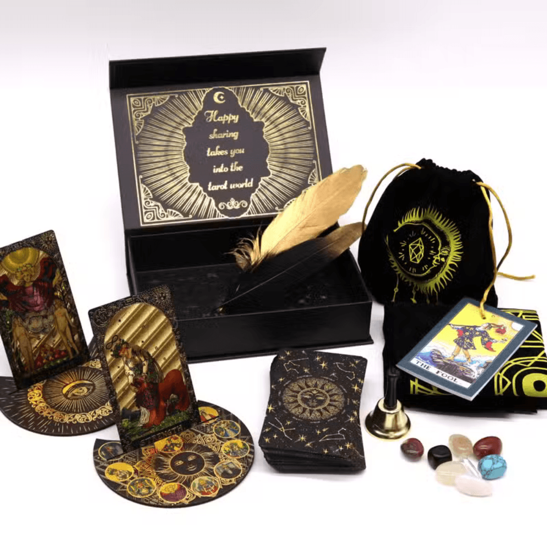 Tarot deck gift set displayed with cards, guidebook, storage pouch, bell, stones, cloth, feather quills and presentation box.