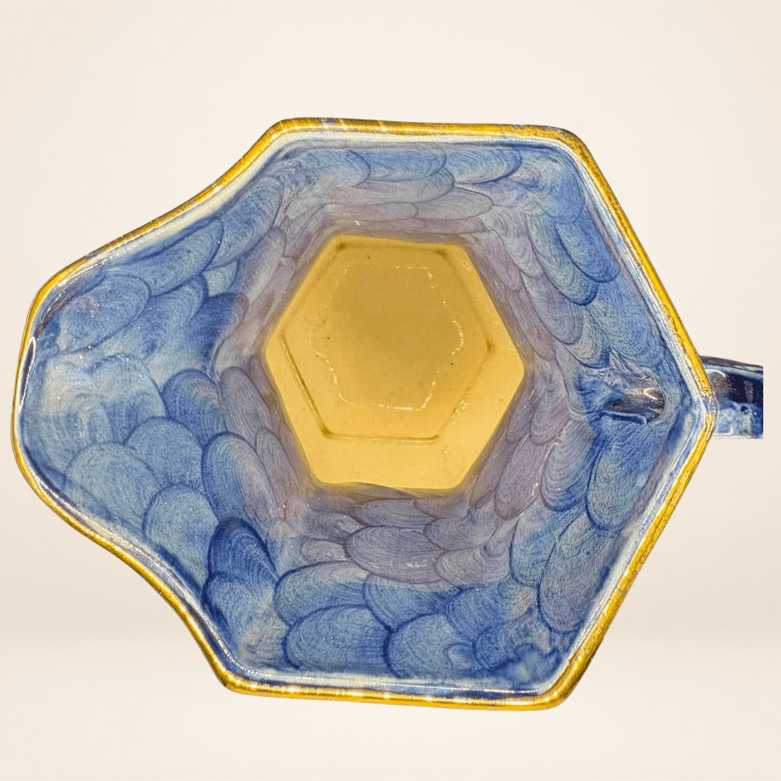 Interior of blue ceramic Maling jug with waved lustre glaze and gilt rim