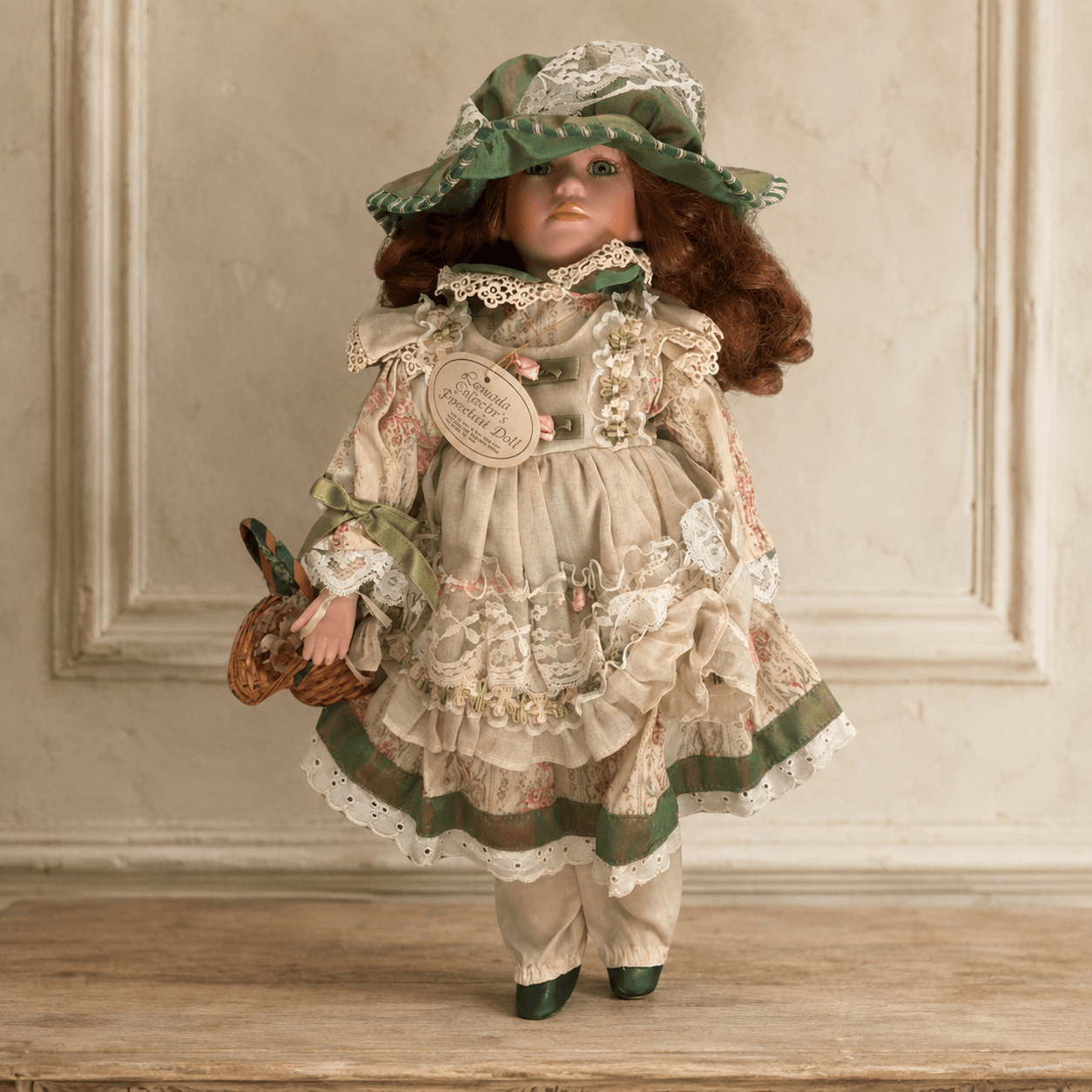 Vintage porcelain doll Rowena in a green floral dress with bonnet and basket