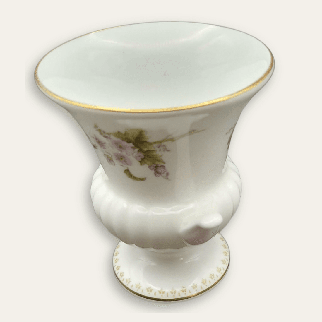 Angled side view of small Wedgwood Mirabelle vase with gilt rim and floral decoration
