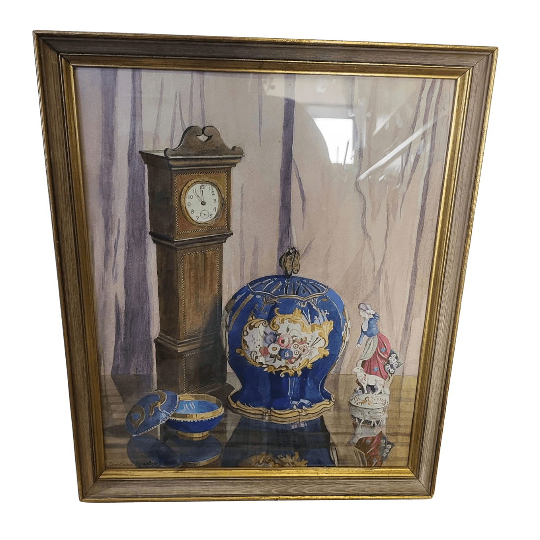 Photograph of the vintage framed watercolour behind reflective glass, showing its wooden frame and gilt-coloured detailing.